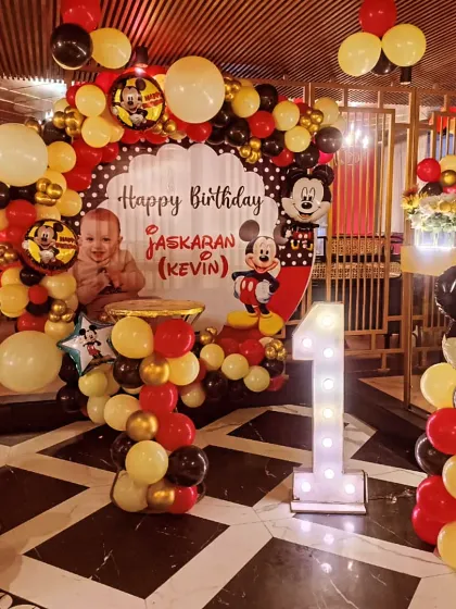 This full view of the Mickey Mouse setup shows how all the elements come together. The personalized backdrop, balloon columns, and marquee number create a fantastic focal point for the celebration.