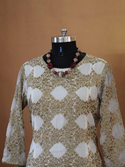 This elegant long kurta features a beautiful gold and white block print. It's a sophisticated piece that can be worn for a casual day at work or a small family gathering.