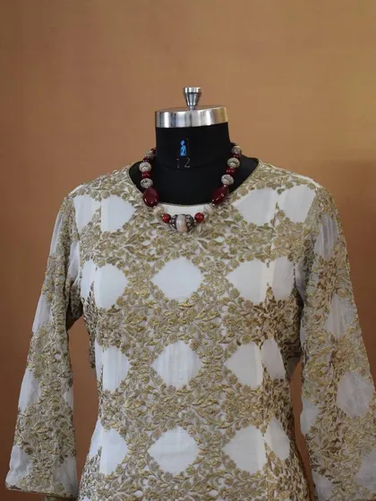 This elegant long kurta features a beautiful gold and white block print. It's a sophisticated piece that can be worn for a casual day at work or a small family gathering.