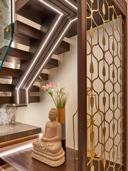 We love to create beautiful moments in transitional spaces. Here, the area under the staircase is transformed with a Buddha statue, elegant vases, and integrated lighting along the steps and handrail.