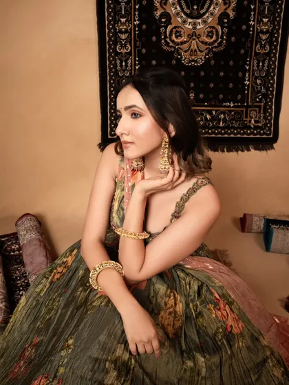 A beautiful, candid-style portrait for a printed lehenga. The model's relaxed pose and the soft lighting create a warm and approachable feel for the brand.