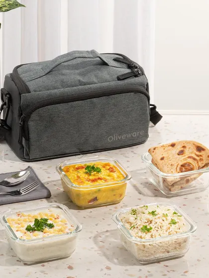 An e-commerce shoot for a lunch bag, styled with a complete Indian meal. This shows the product's capacity and practical use for carrying a variety of dishes like dal, rice, and roti.