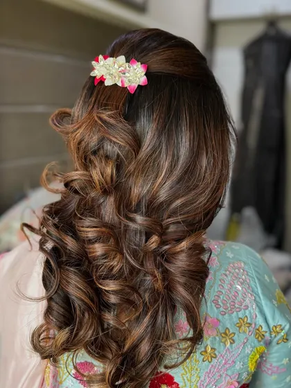 Another angle of the bouncy curls, showing how the style has volume at the crown and cascades down. This look is perfect for a wedding guest who wants a polished yet glamorous hairstyle.