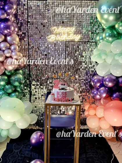 A unique and moody party theme with a silver sequin wall and a balloon garland in shades of purple, green, and chrome. This is a great example of a custom color palette.