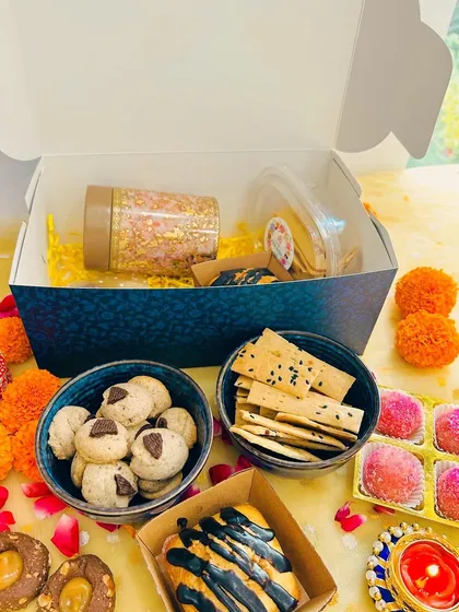 A deconstructed view of the 'Khushiyon Ki Diwali' Box, showing all the delicious components like the cube cake, cookies, lavash, and laddoos.