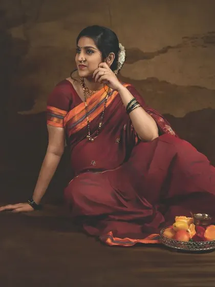 A relaxed, seated pose with a fruit platter, reminiscent of traditional Indian paintings. This setup adds a story-like quality to the maternity photo.