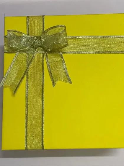 A simple yet elegant yellow gift box, tied with a golden ribbon. This is the starting point for a fully customized hamper.