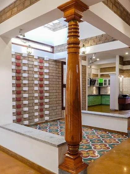 The pooja space, with its patterned wall and traditional columns, is designed to be a point of emphasis within the home.