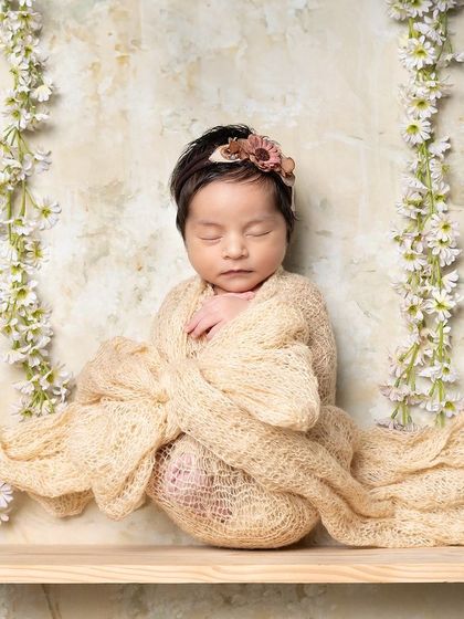 The newborn phase is a beautiful memory. This simple, elegant shot on a wooden swing captures the tininess of your baby, creating a photo you'll cherish for years.