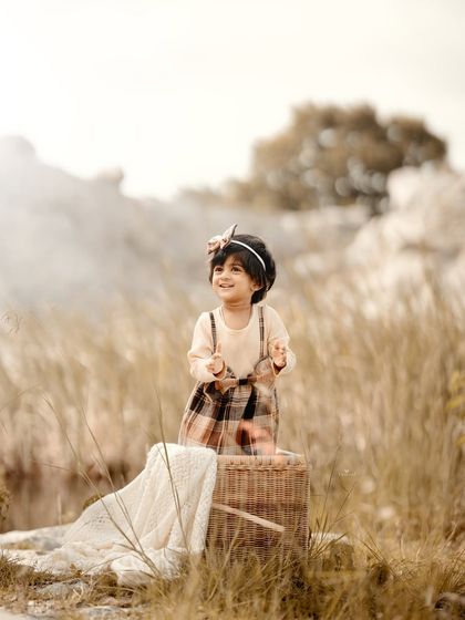 Looking up with a happy expression, this little girl is enjoying the fresh air and open space.