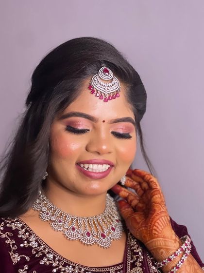A happy, smiling shot of Hima. Her glowing skin and bright eyes are the highlight of this glamorous reception look.