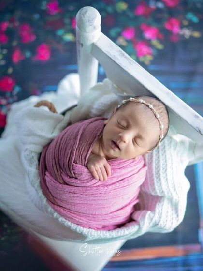 An angled shot of the hanging prop, creating a dynamic and artistic newborn portrait.
