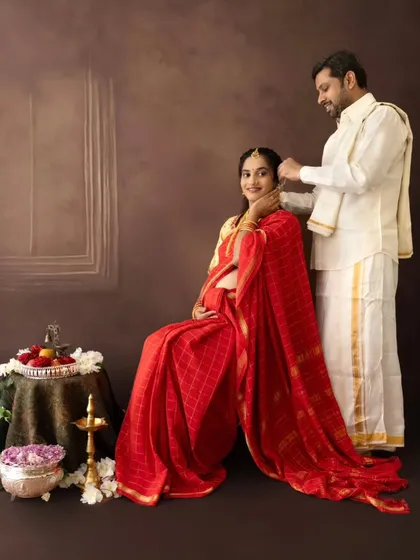 A sweet gesture where the husband-to-be lovingly places flowers in his wife's hair during their traditional maternity session.
