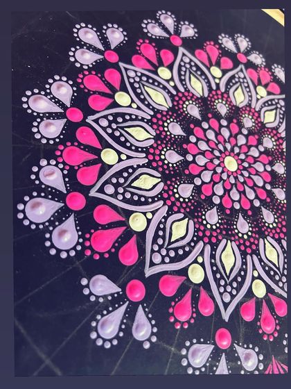 A work-in-progress shot of a pink and purple dot mandala, showing the layers and details coming together.