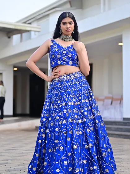 A striking look in a royal blue embroidered lehenga. The makeup is clean and sharp, with a focus on flawless skin and defined features to match the regal outfit.