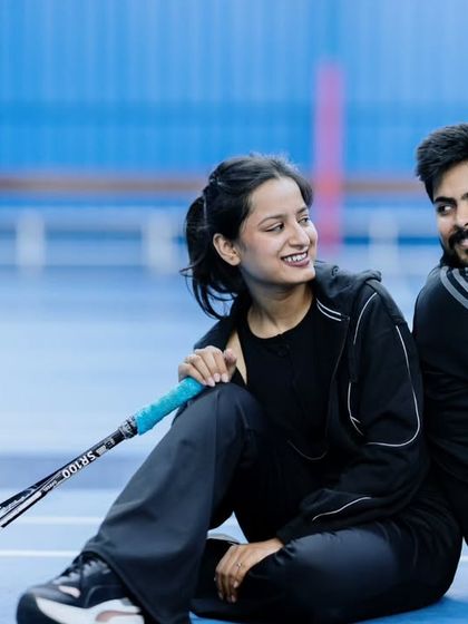 A candid moment of laughter between the couple during their badminton-themed pre-wedding shoot. It's these unposed, genuine interactions that make a photoshoot special.