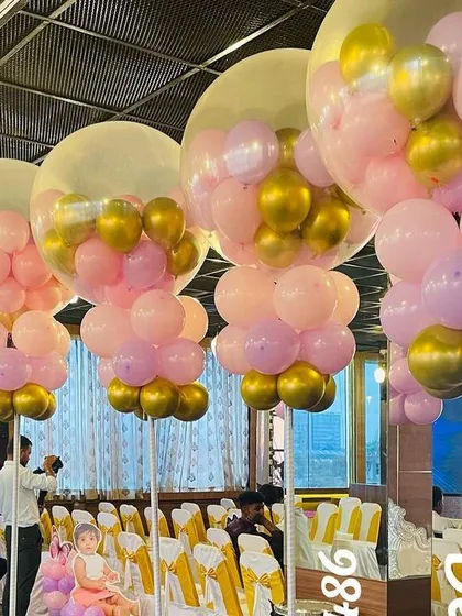 To fill a large party hall, I created these stunning balloon columns for a butterfly-themed birthday. Each column consists of a large clear bubble balloon filled with smaller pink and gold balloons, creating a magical floating effect.