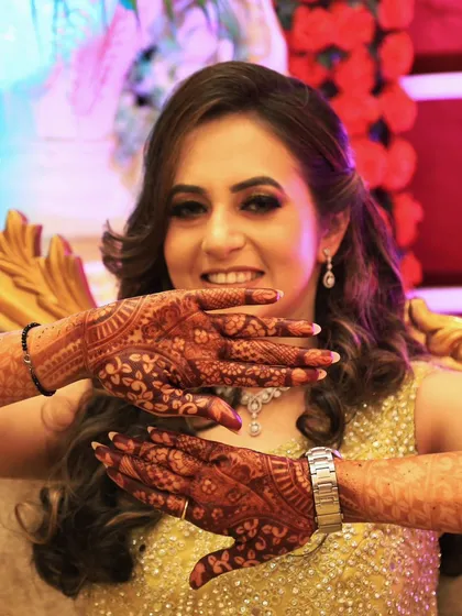 The joy of a bride-to-be, beautifully captured. Her hands are adorned with floral mehendi, ready for her big day.