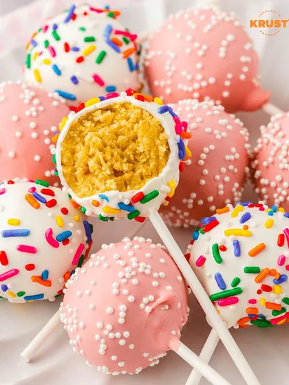 A close-up of colorful cake pops, one with a bite taken out to show the delicious cake inside. A tempting preview of what you'll make in our workshop.