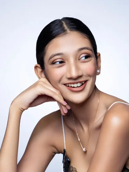 A smiling portrait for Nutan Jewellers. This shot has a warm, approachable feel, showcasing the modern swan necklace in a relatable way.