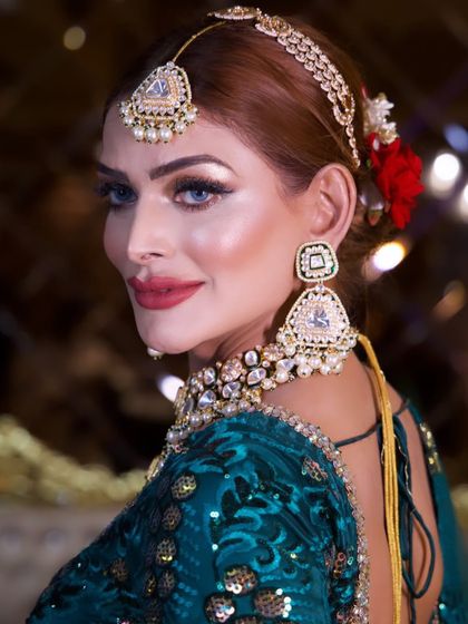 A beautiful close-up of the celebrity look, with a red rose in her hair. The details, from the perfectly blended skin to the crisp red lip, are what make this look special.