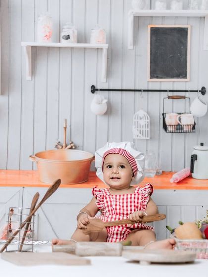Happiness is a swing set and a best friend. A little chef sits in our kitchen setup, ready to play with wooden spoons.