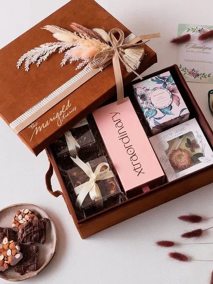 Unwrap the magic of Diwali with this hamper featuring a wax tablet, a tin candle, and boxes of our hazelnut cookies, nutty barks, and clusters.