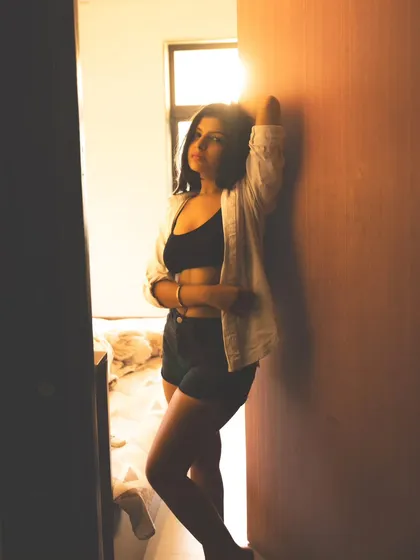 A confident pose in a doorway, using the natural light from the room to create a beautiful silhouette effect.