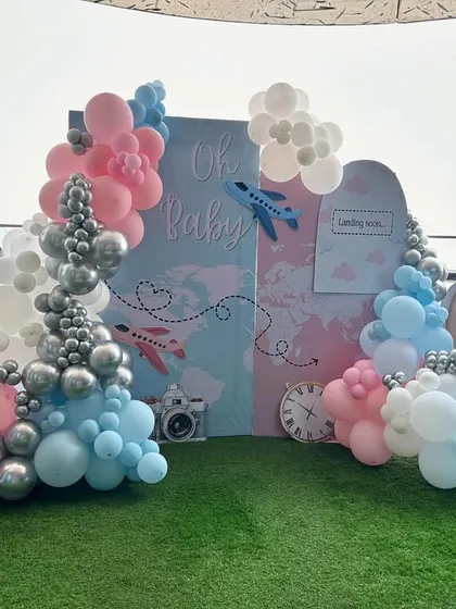 Adventure awaits! This travel-themed baby shower decor is perfect for celebrating a new journey. We used a world map backdrop, airplane and hot air balloon props, and balloon clouds in soft pinks and blues to create a whimsical and exciting setup on a beautiful balcony.