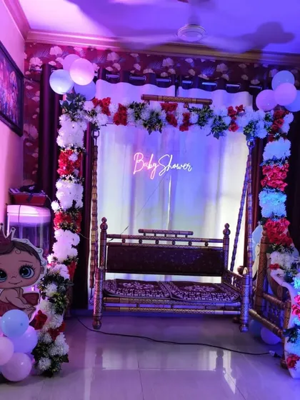 A side view of the baby shower swing decoration with party lighting.