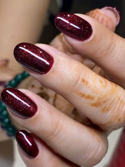 A deep, sparkling burgundy polish. The glitter adds dimension and a touch of festive glamour to this classic dark shade.