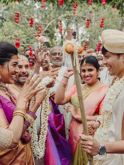 A playful moment during the 'Kashi Yatra' ritual, where the bride's family persuades the groom to choose marriage over asceticism.