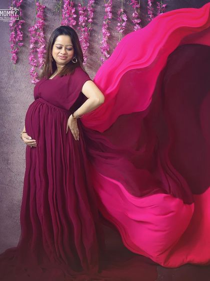 The beauty of a flowing gown in motion. In the studio, we can play with fabrics and lighting to create stunning, glamorous maternity photos like this one.
