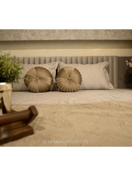 A close-up of the bedding details in a parent's bedroom. We believe in layering textures, like these round velvet cushions, to add warmth and a sense of luxury to the space.