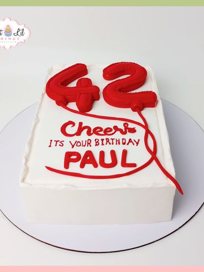 A bold and modern number cake for a 42nd birthday. This minimalist design features balloon-style numbers in bright red on a clean white canvas.