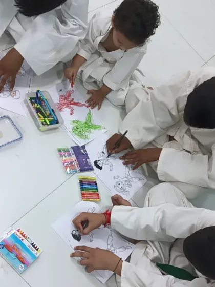 A group of boys working together on their coloring pages. It's a peaceful end to an energetic karate session.