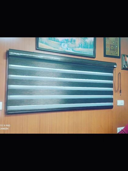 A set of zebra blinds installed in an office. These blinds allow you to switch between sheer and solid panels, giving you flexible control over light and visibility.
