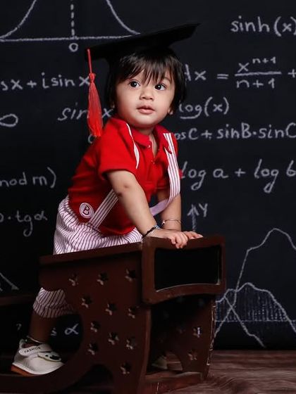 Our little graduate is ready to take on the world. The chalkboard backdrop adds a fun, academic touch.
