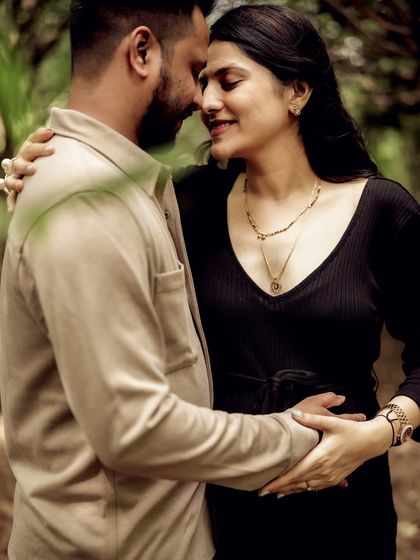 A close-up, intimate portrait of the couple embracing in the woods. The soft light and their gentle expressions make this a very romantic shot.