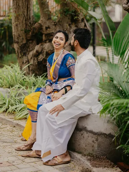 A candid laugh shared between the couple while sitting on a park bench, showcasing a genuine moment from their pre-wedding shoot.