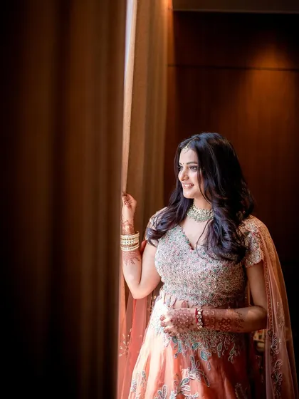 The bride-to-be gazes out a window, captured in a moment of quiet anticipation.