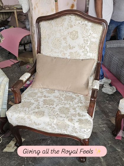 For those who love a touch of royalty, this classic armchair is perfect. It features a dark, carved wood frame, elegant floral upholstery, and a comfortable lumbar pillow.