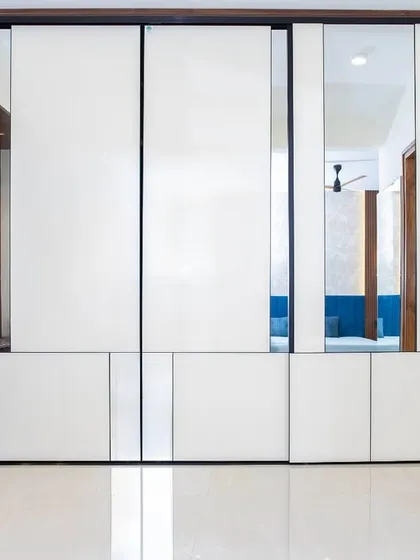 This Aristo wardrobe with high-gloss white panels and subtle mirror details enhances both form and function. The sliding doors glide with ease, maximizing space and light.