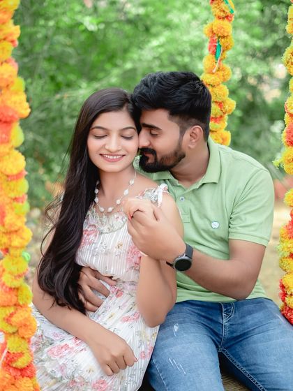 A sweet and tender moment on a swing decorated with marigold flowers. This setup combines traditional elements with a playful, romantic feel.