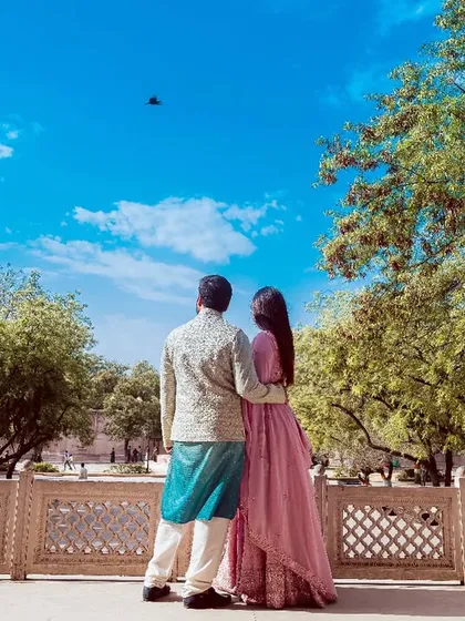 A pre-wedding shoot in Jaipur, with the couple looking out at the sky from a heritage location. I love using grand backdrops to tell your story.