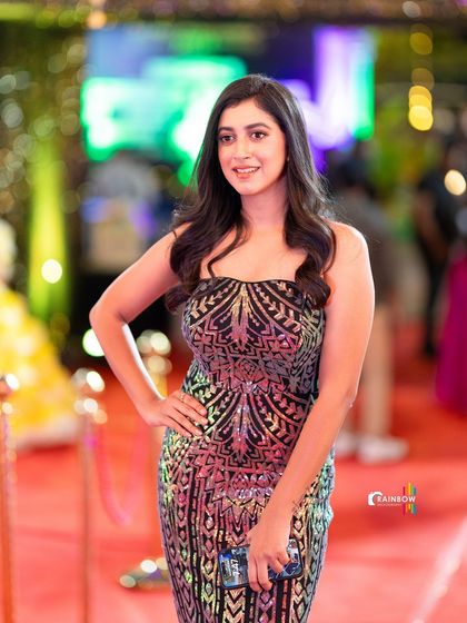 A guest looking glamorous in a sequined gown, with the beautiful bokeh of the event lights creating a perfect backdrop.