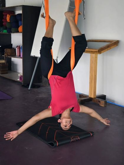 The pure bliss of hanging upside down. This student is finding a moment of peaceful surrender in her aerial practice, letting go of tension and stress.
