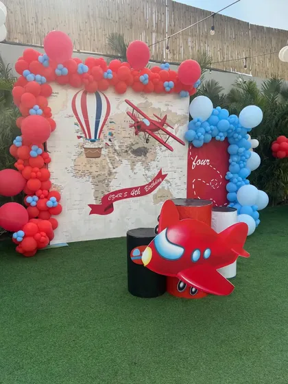 An "Up and Away" aeroplane theme for a little traveler's birthday, featuring a world map backdrop and vintage plane props.