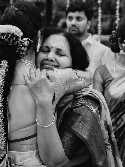 Sometimes, the most powerful emotions are best expressed without color. This black and white photograph of a heartfelt embrace between a bride and her mother captures the raw, tearful joy of the moment, creating a truly timeless and moving image.