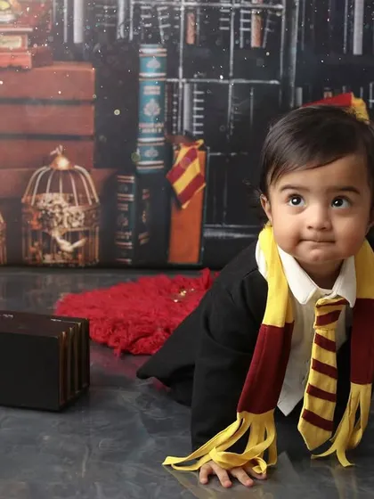 On the move in the magical world. This crawling shot captures the curiosity of a one-year-old exploring the detailed Harry Potter set, from the vintage clock to the tiny suitcase prop.